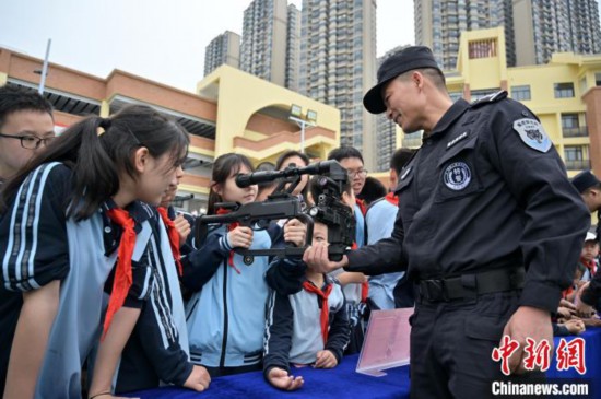 广西南宁：特警进校话平安 “萌娃”体验高精尖装备